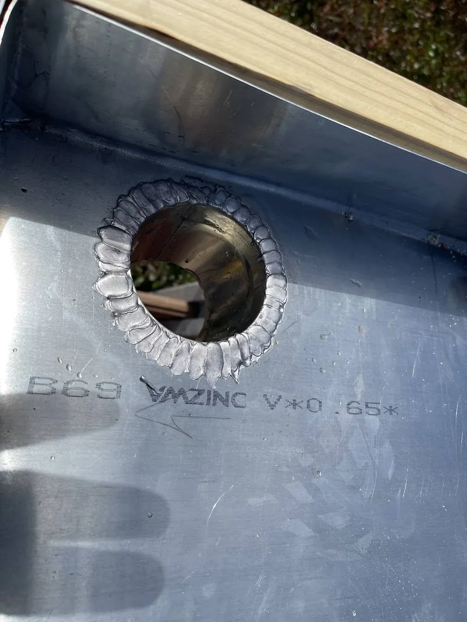 Détail d’un raccord circulaire soudé dans une pièce de zinguerie.